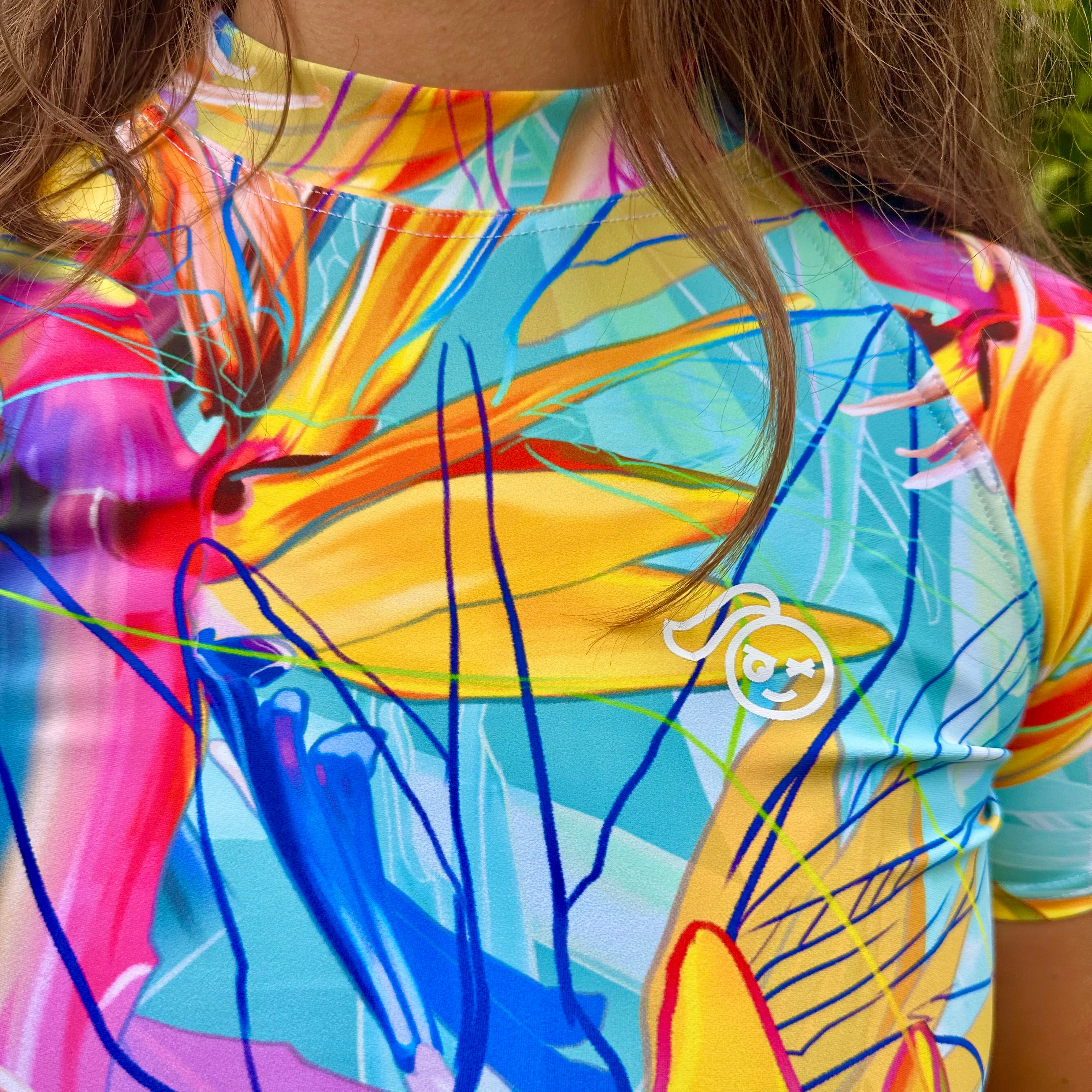 Tough Cherry Tropical Flora turquoise design Rash Guard close up of Tough Cherry Logo