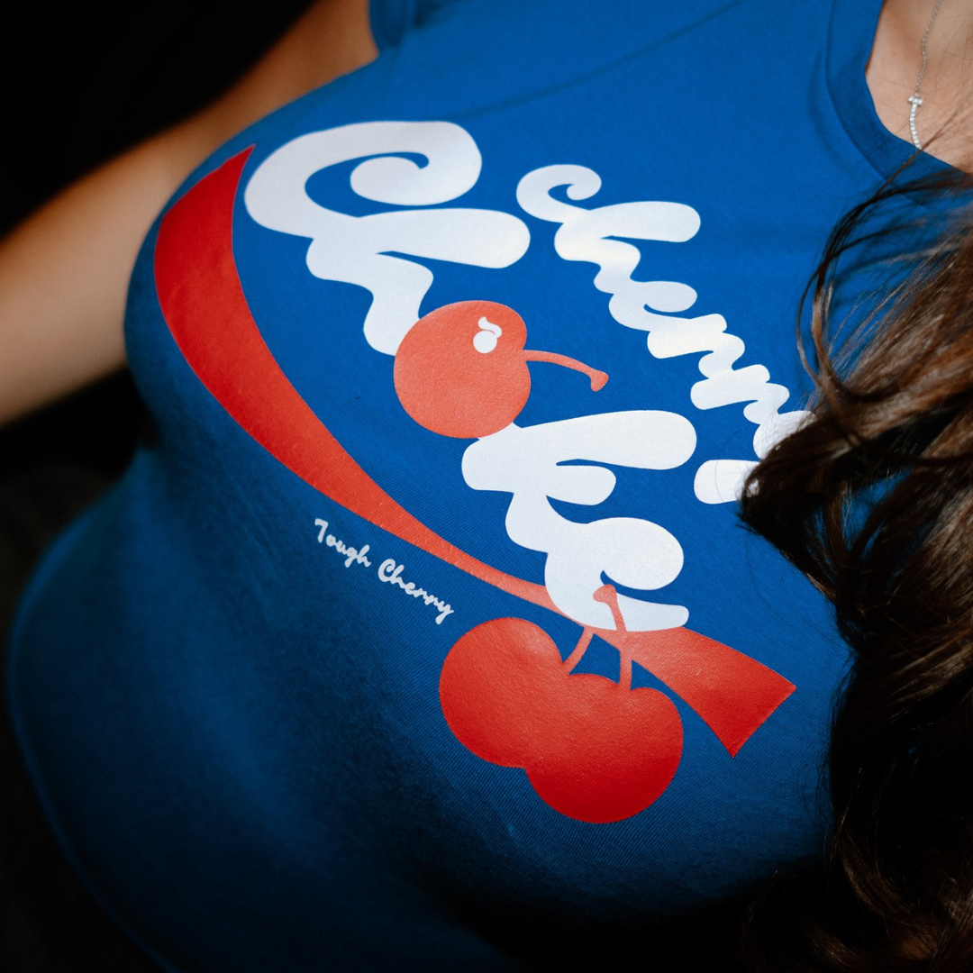 Blue t-shirt with red and white graphic design saying tough cherry cherry choke.