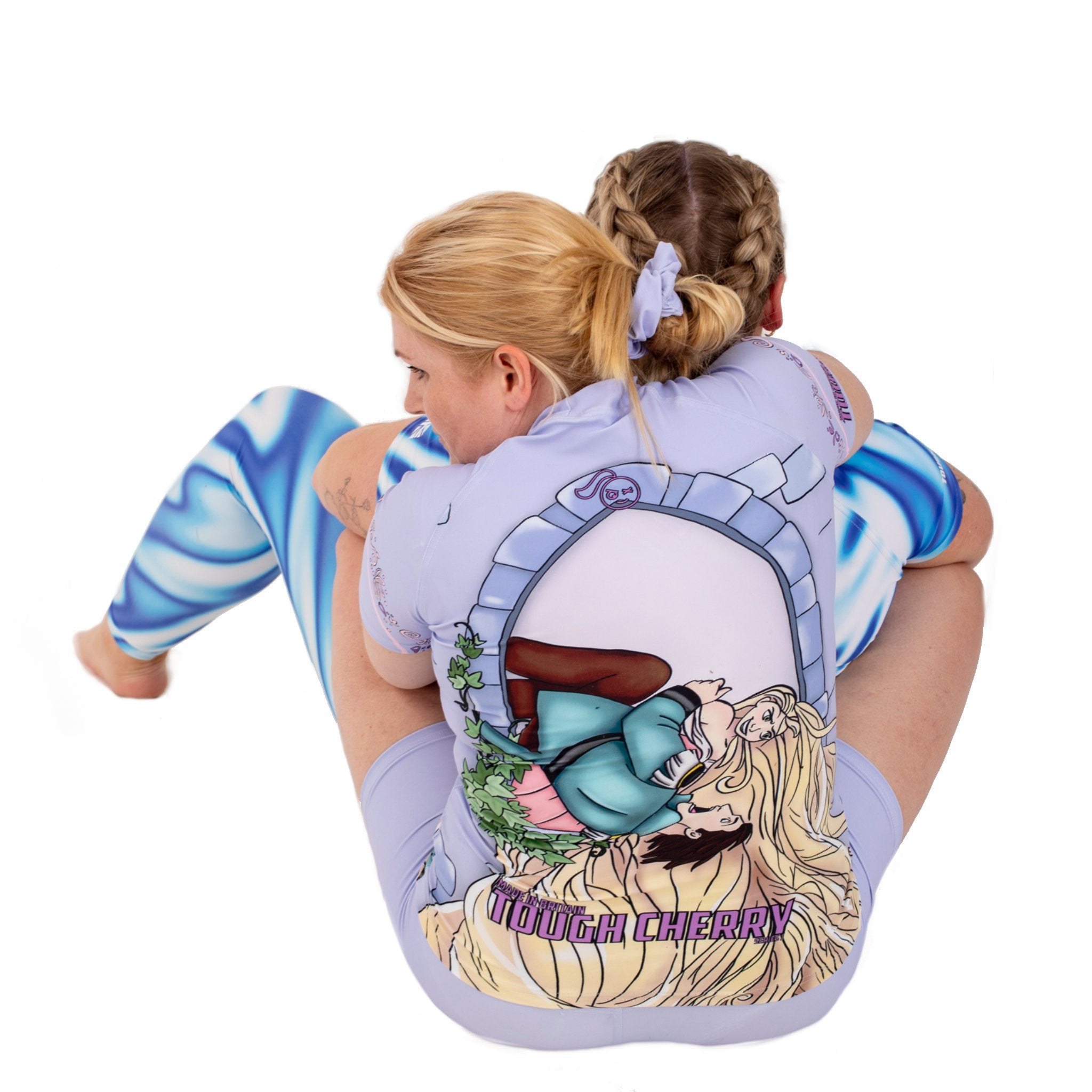 Women in rash guards doing jiu jitsu