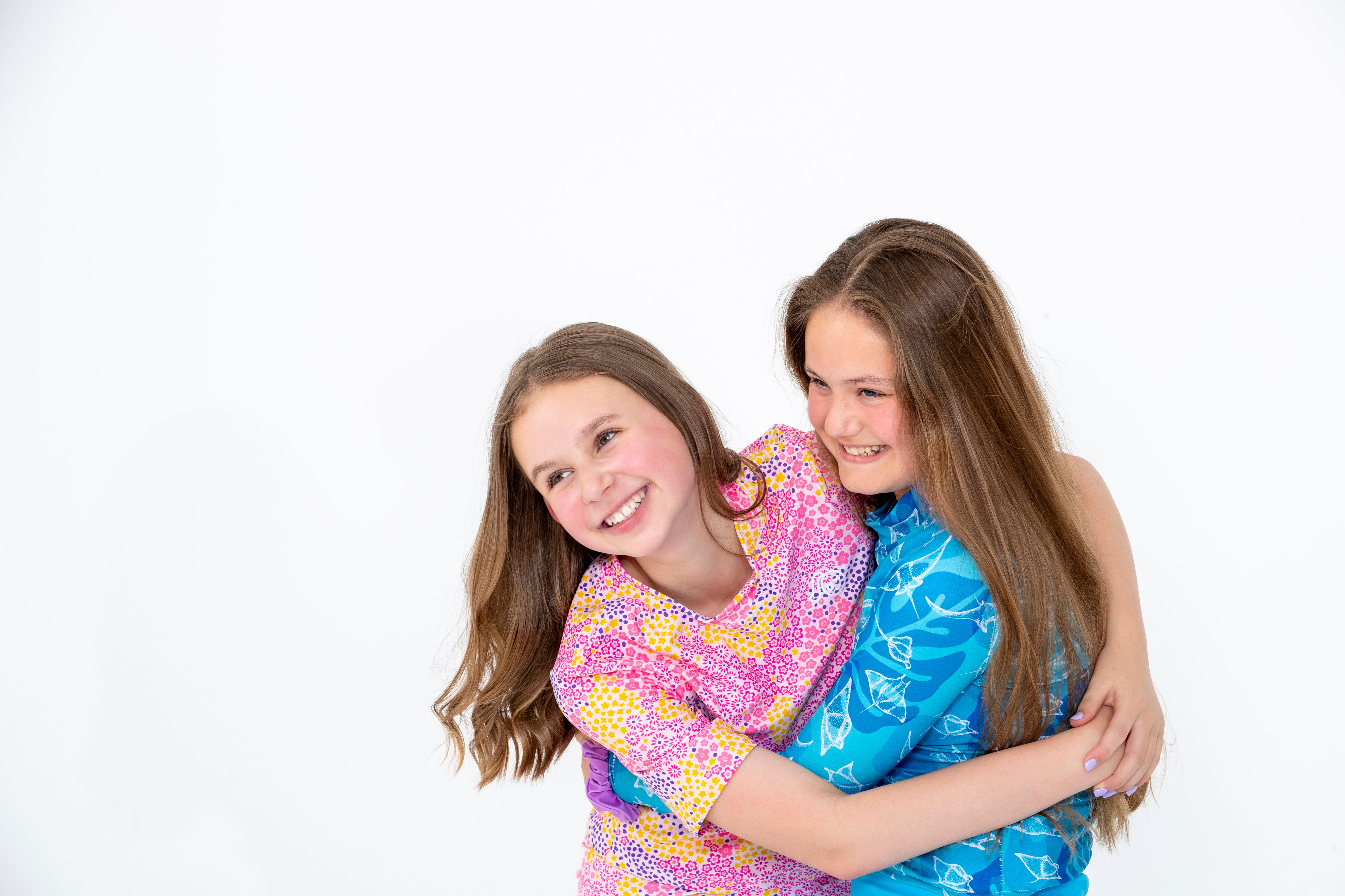 two girls hugging in tough cherry rash guards