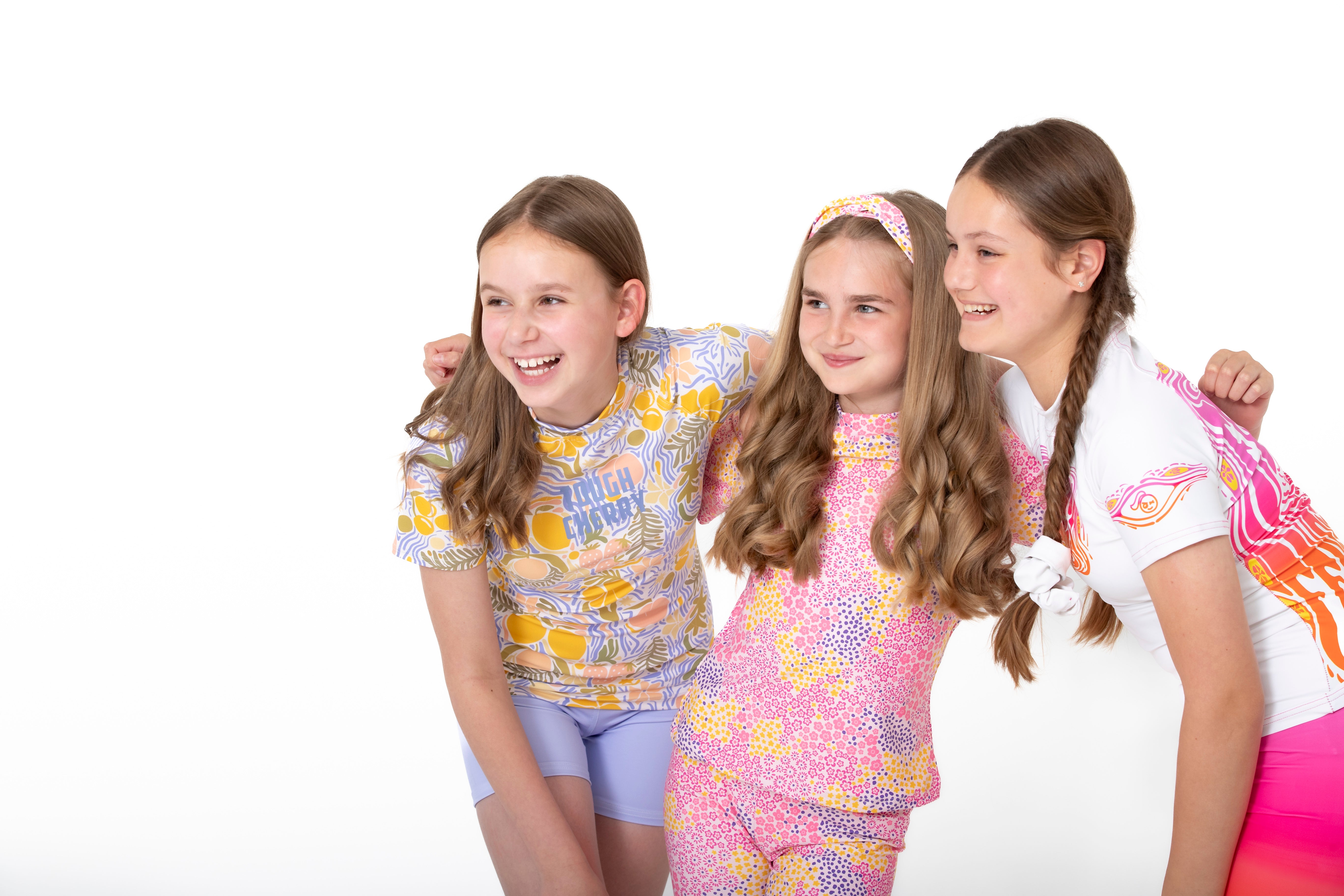 three girls in colourful tough cherry rash guards smiling