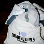 I love jiu jitsu girls tote bag filled with gym clothes and tough cherry trucker cap poking out