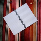 Open notebook with lined pages on a striped fabric background