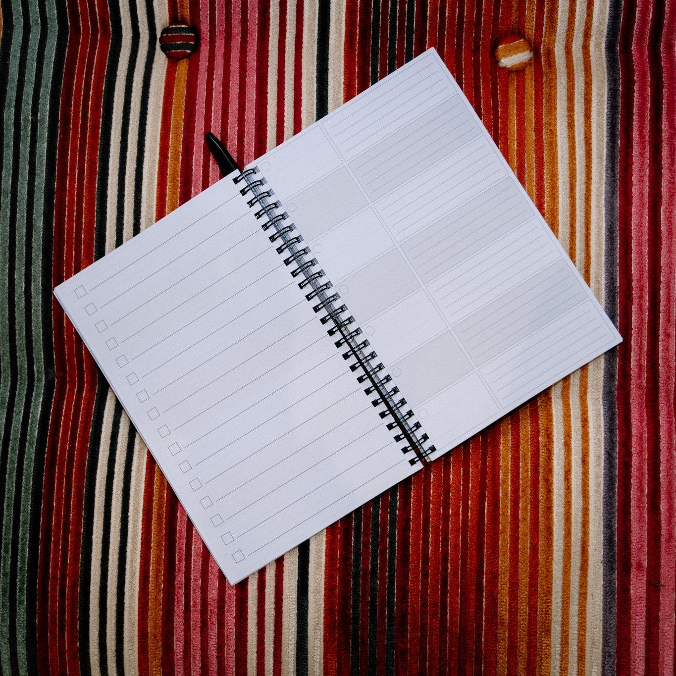 Open notebook with lined pages on a striped fabric background