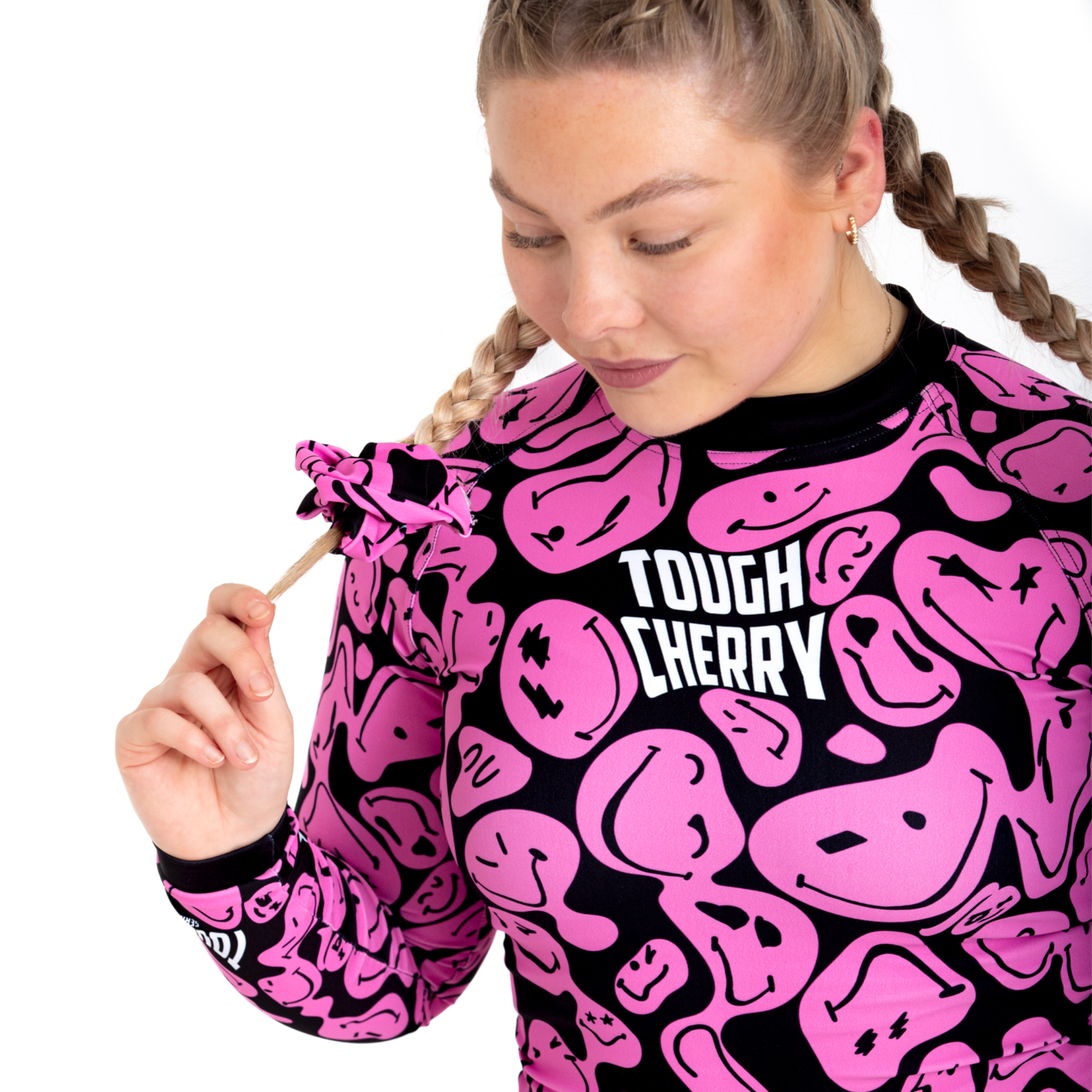 Women's and kids long sleeved pink and black smiley face rash guard, logo view