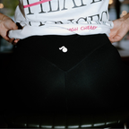 Person wearing a white t-shirt with text and black tough cherry leggings, holding the waistband.
