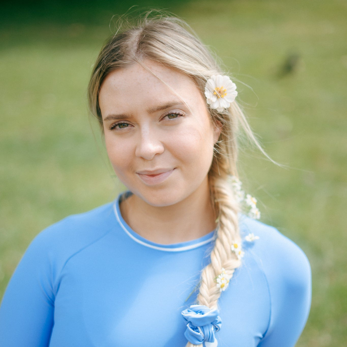 Woman in a blue tough cherry rash guard with a braided hairstyle outdoors