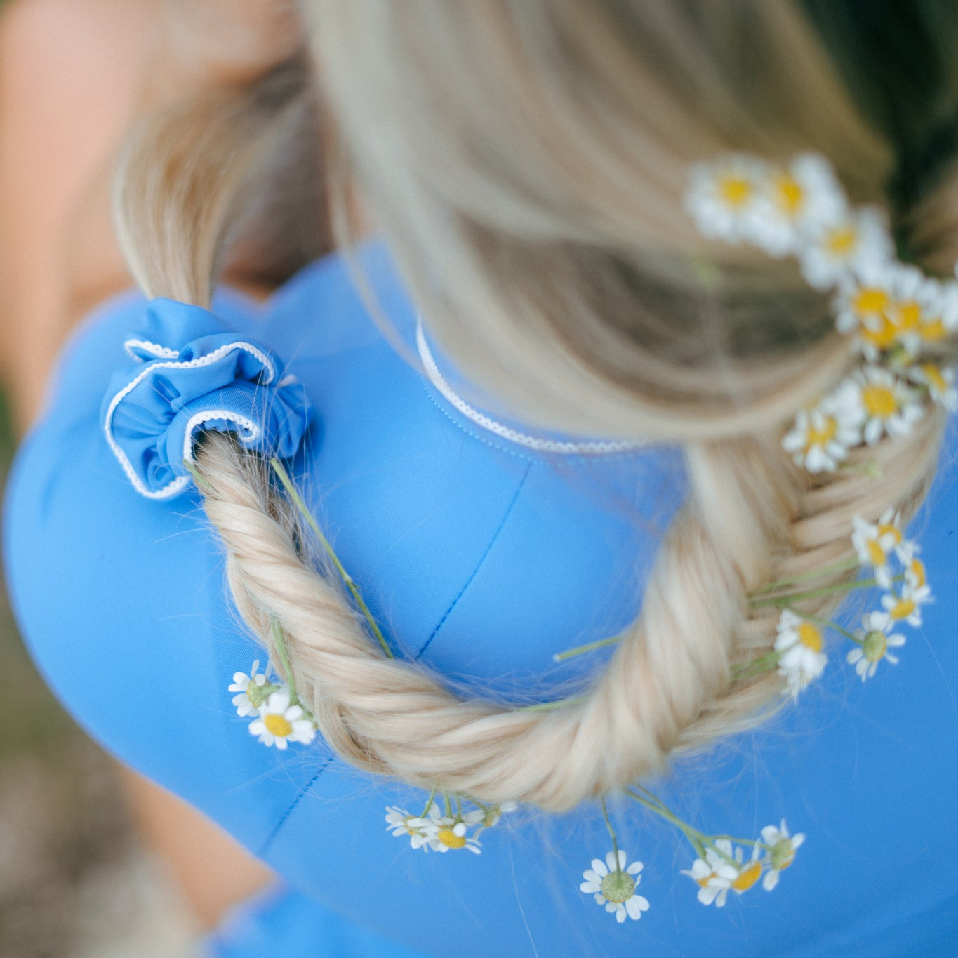girl with daisy flowers in her hair with a blue tough cherry scrunchies with lace detailing 