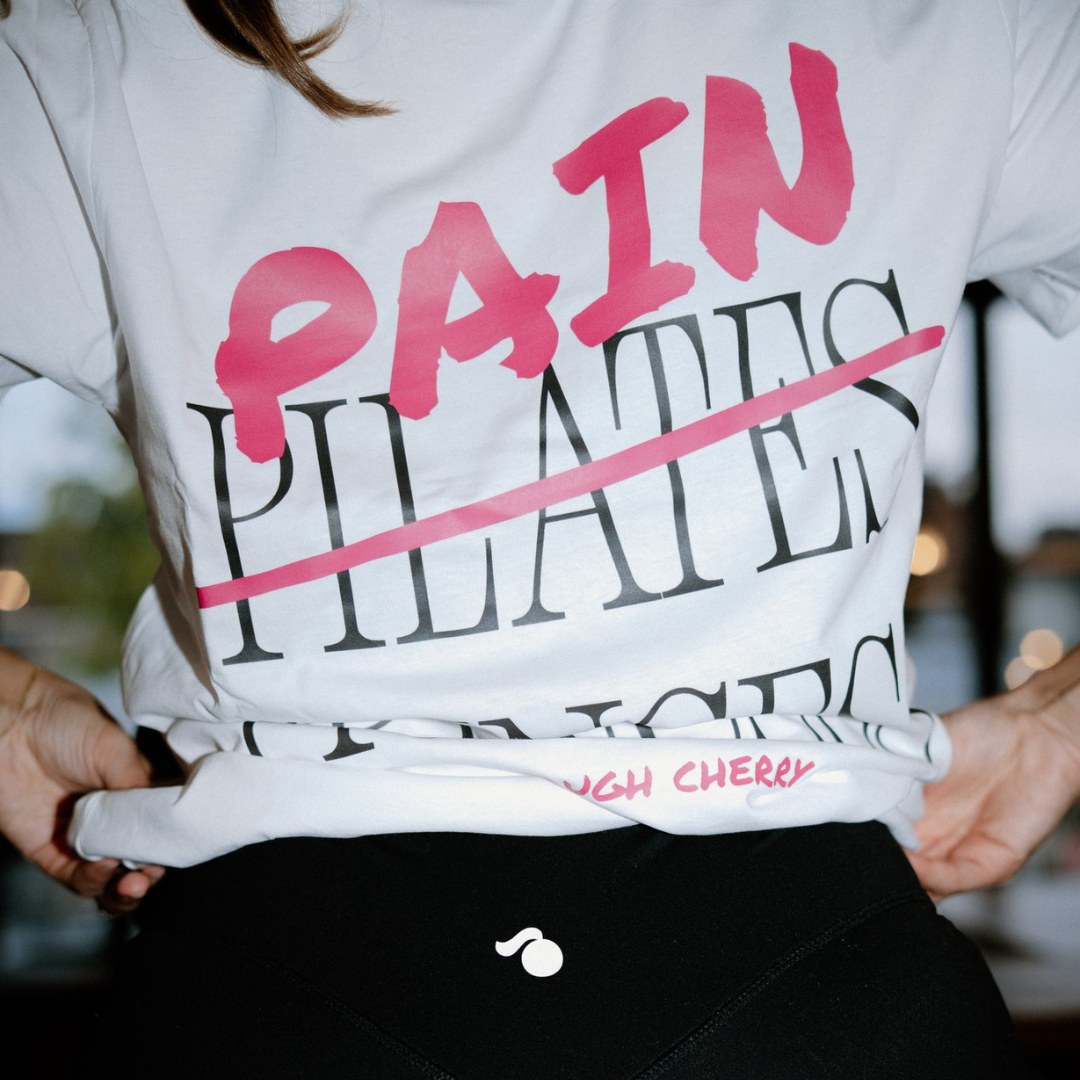Person wearing a white t-shirt with pink and black text saying pain princess.